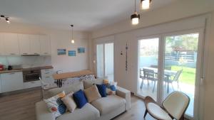 a living room with a couch and a kitchen with a table at To Helidoni Apartment & Gardens in Nikiti