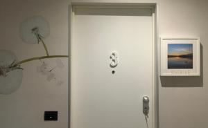 Una puerta con el número ocho en una habitación en 7 LAKES Aparthotel, en Burolo