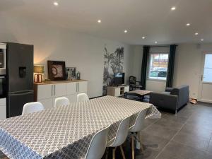 a room with a table and chairs and a kitchen at Les prunelles maison de village de 4 à 8 personnes in Précigné