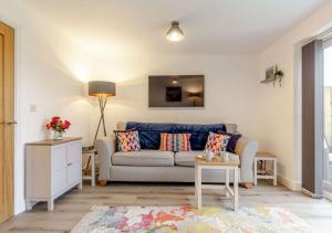 a living room with a couch and a table at Buttercup Cottage in Saint Ervan