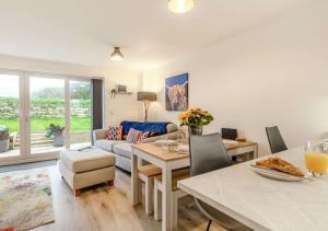 a living room with a couch and a table and chairs at Buttercup Cottage in Saint Ervan