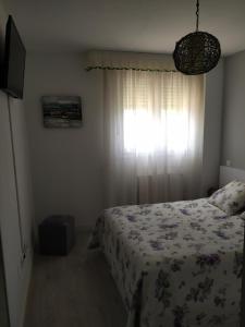 um quarto com uma cama e uma janela em Apartamento Casa Labaro, junto al Parque de Cabárceno em Arenal