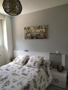 um quarto com uma cama e um quadro na parede em Apartamento Casa Labaro, junto al Parque de Cabárceno em Arenal