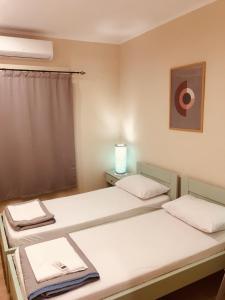 Zimmer mit 2 Betten und einem Fenster in der Unterkunft Casa Mersini in Chania