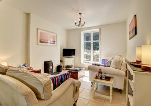 een woonkamer met 2 banken en een tv bij River Cottage in Lynmouth