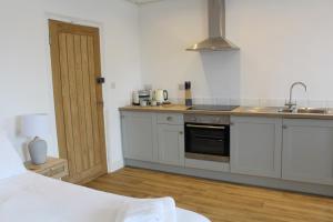 a kitchen with white cabinets and a sink at Pike O'Stickle in Bowness-on-Windermere