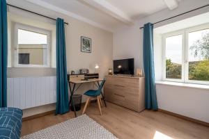 a bedroom with a desk and a computer in a room at L'esprit cozy in Audincourt