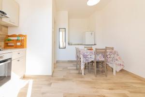 a kitchen and dining room with a table and chairs at Via Roca 55 in Melendugno