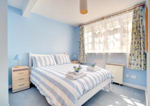 a blue bedroom with a bed and a window at River View in Lynmouth
