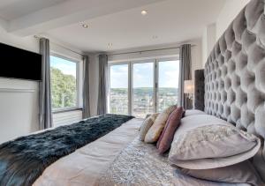 a bedroom with a large bed with a large window at Rock House in Ilfracombe