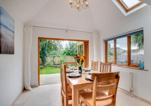 een eetkamer met een houten tafel en stoelen bij Sanderling in Braunton