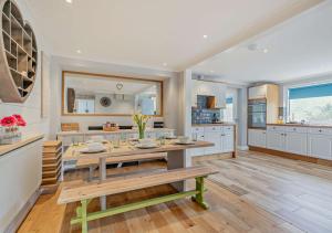 a kitchen with a table and a dining room at The Beach House - Porthcurno in Saint Levan