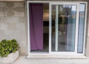 una porta scorrevole in vetro con una tenda viola di Studio Apartment Kastel Star a Kaštela (Castelli)