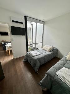 a bedroom with two beds and a flat screen tv at PATAGONIA FLAT in Esquel