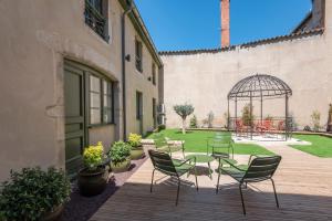 a patio with chairs and a table and a gazebo at Le Boho . Centre-ville Mâcon . Proche gare . Design . Neuf . Wifi . Climatisation . Confort in Mâcon