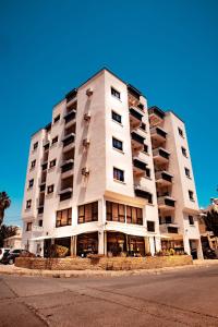 a large white building with windows on a street at Olive Island in Larnaka