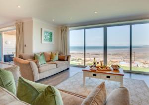 a living room with a couch and a table at Sea Spray in Westward Ho