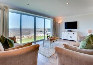 a living room with chairs and a large window at Sea Spray in Westward Ho