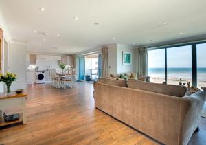 a living room with a couch and a kitchen with the ocean at Sea Spray in Westward Ho