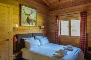 a bedroom with a bed with a deer picture on the wall at Chalet de l'Atray in Les Gets