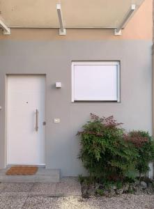 a white building with two doors and a plant at STUDIO 14 - due biciclette incluse in Treviso
