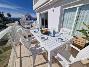 einen weißen Tisch und Stühle auf dem Balkon in der Unterkunft V19 Ático con impresionantes vistas al mar B16 in Denia