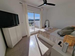Schlafzimmer mit einem Bett und einem Flachbild-TV in der Unterkunft V19 Ático con impresionantes vistas al mar B16 in Denia