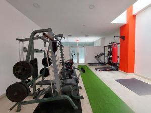 - une salle de sport avec 2 tapis de course et un tapis de course vert dans l'établissement PLATINO SUITE CON PISCINA, GIMNASIO Y PARQUEO, à Guayaquil