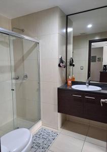 uma casa de banho com um chuveiro, um WC e um lavatório. em PLATINO SUITE CON PISCINA, GIMNASIO Y PARQUEO em Guayaquil