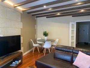 ein Wohnzimmer mit einem Ledersofa und einem Tisch in der Unterkunft Lucky home in Pontevedra