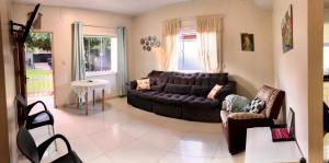 a living room with a leather couch and chairs at Casa Bignonia Amplio y confortable Ideal para familias con niños in Ciudad del Este