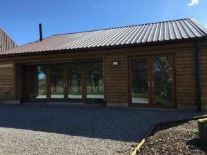 萊本的住宿－The Mistal@Cow Close Barn, Leyburn - Relax, and Enjoy，玻璃门和金属屋顶的建筑