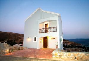 3 bedrooms house at Kalymnos 350 m away from the beach with sea view enclosed garden and wifi في كاليمنوس: منزل أبيض مع شرفة على تلة