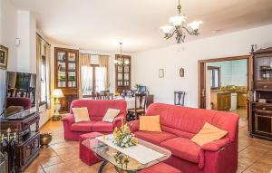 a living room with two red couches and a table at Spacious villa with private pool near Priego de Cordoba in Priego de Córdoba
