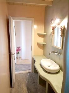 ein Bad mit einem Waschbecken und einem Spiegel in der Unterkunft 3 bedrooms house at Kalymnos 350 m away from the beach with sea view enclosed garden and wifi in Kalymnos