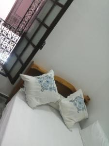 uma cama com almofadas num quarto em Bab aissi home em Meknès