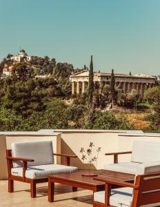 een patio met 2 stoelen en een tafel en een gebouw bij Suitas in Athene