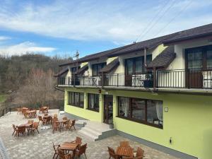 a building with tables and chairs in front of it at Complex Turistic Cetatea Drencova 