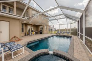 een zwembad met een glazen dak boven een huis bij Oasis Villa - Heated Pool And Spa Near Disney in Davenport