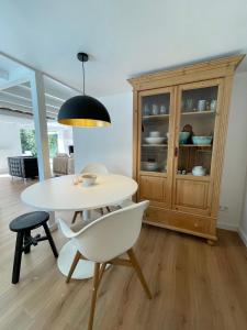 a dining room with a table and chairs and a cabinet at Duinstudio Bergen in Bergen
