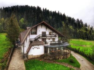 ein Haus inmitten eines Feldes mit Bäumen in der Unterkunft Hotel Ieremia Movila in Suceviţa