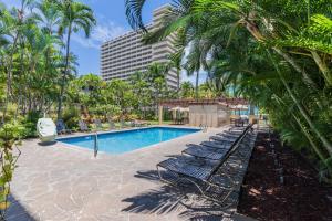 a resort swimming pool with lounge chairs and palm trees at Royal Garden Waikiki - Wyndham Resort in Honolulu