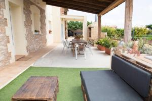 a patio with a wooden table and chairs and a table and a table at 3 bedrooms house with private pool enclosed garden and wifi at Camarles 5 km away from the beach in Camarles