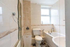 een badkamer met een toilet, een bad en een wastafel bij The Stratford Victoria in Londen