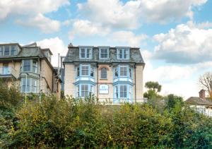 a large brick house with a blue trim at St Agnes Sleeps 6 in Ilfracombe