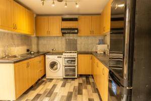 a kitchen with wooden cabinets and a washer and dryer at The Stratford Victoria in London