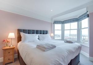 a bedroom with a large white bed with a window at St Agnes Sleeps 6 in Ilfracombe
