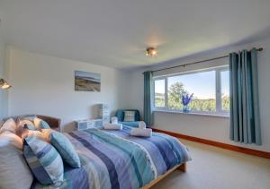 um quarto com uma cama e uma grande janela em Sundowner em Croyde