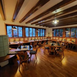 un restaurante con mesas y sillas de madera y ventanas en Brauereigasthof Schlüsselkeller, en Giengen an der Brenz