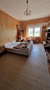 Un dormitorio con una cama grande y una lámpara de araña. en Varga Vendégház en Iregszemcse